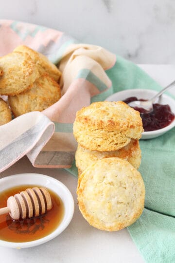 Drizzling honey on halved biscuit.