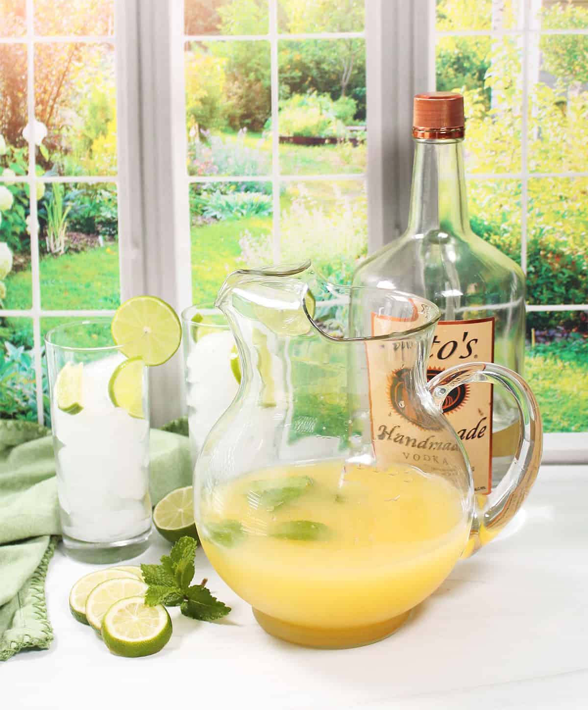Ingredients for limeade with vodka mixed in pitcher.