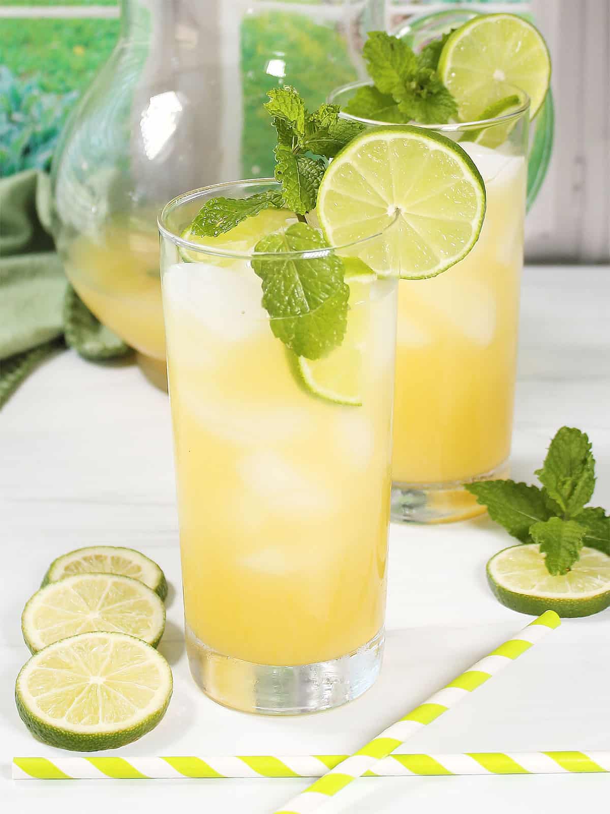 Two vodka limeade cocktails with garnishes.