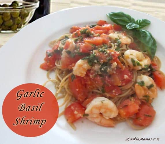 Shrimp with sauce on top of pasta on white plate with basil garnish. Text overlay stating Garlic Basil Shrimp. 