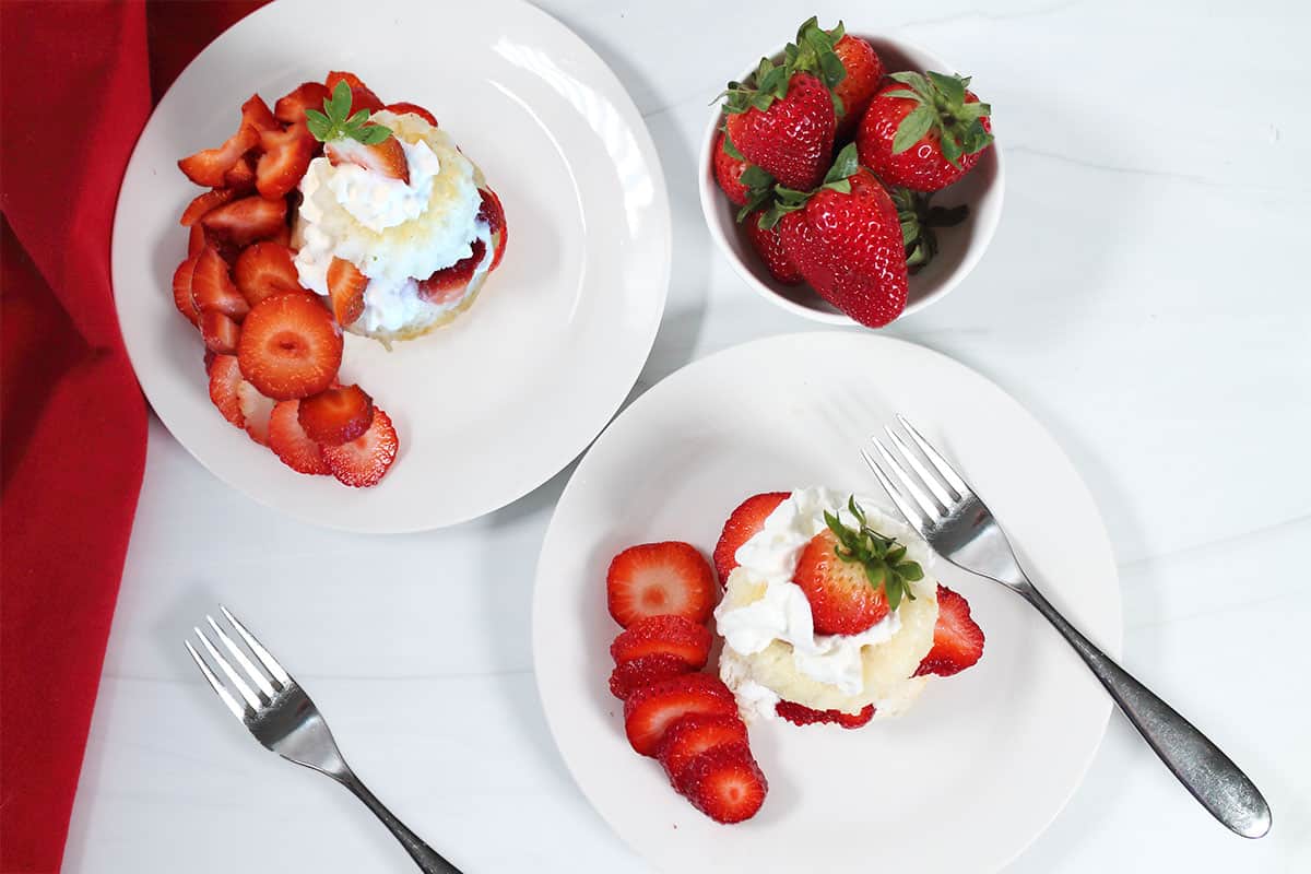 Two servings of mini strawberry shortcakes plated.