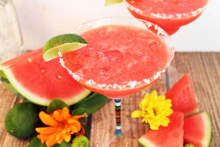 Single margarita from side on wooden table showing frozen mixture.