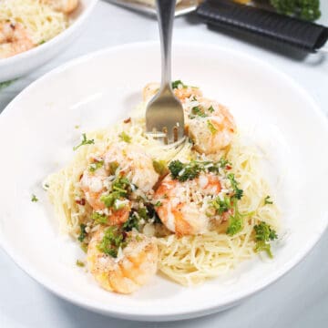 Shrimp Pasta with white wine sauce in serving bowl with fork.