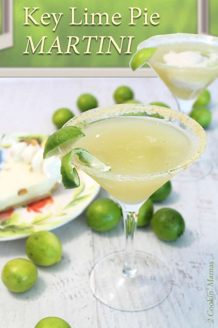 A filled martini glass with a lime wedge sits on a white table with key limes and key lime pie beside it.