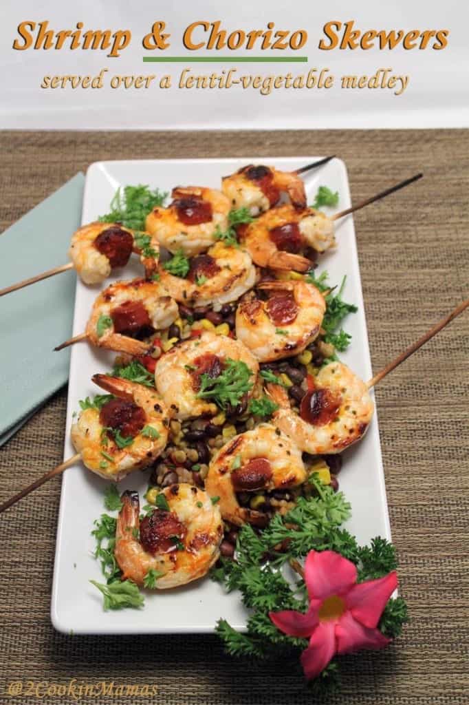 Shrimp & Chorizo Skewers closeup with red flower on white platter.