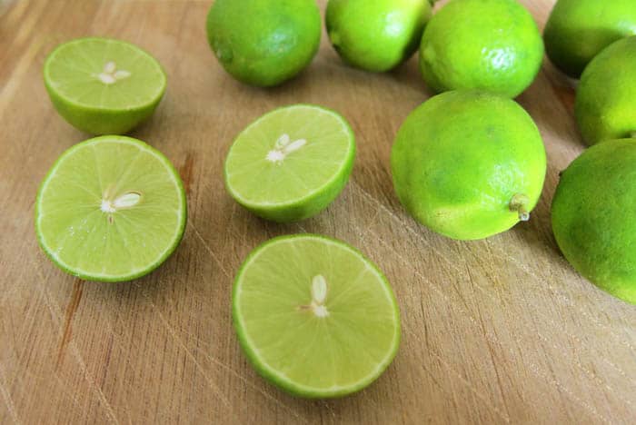 A group of key limes with 2 cut in half.