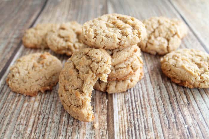 Cookies on wooden table with bite taken out of one.