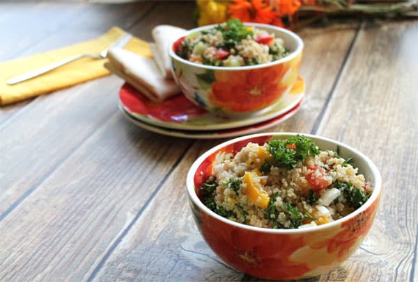 Quinoa Tabouli in spring flower bowls on wooden table.