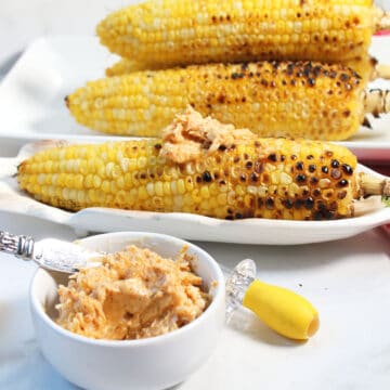 Smear of butter on sweet grilled corn in back of bowl of chili butter.