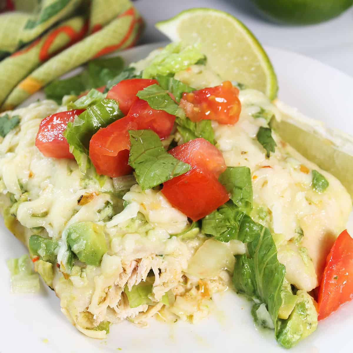 Plated chicken avocado enchiladas showing inside filling.