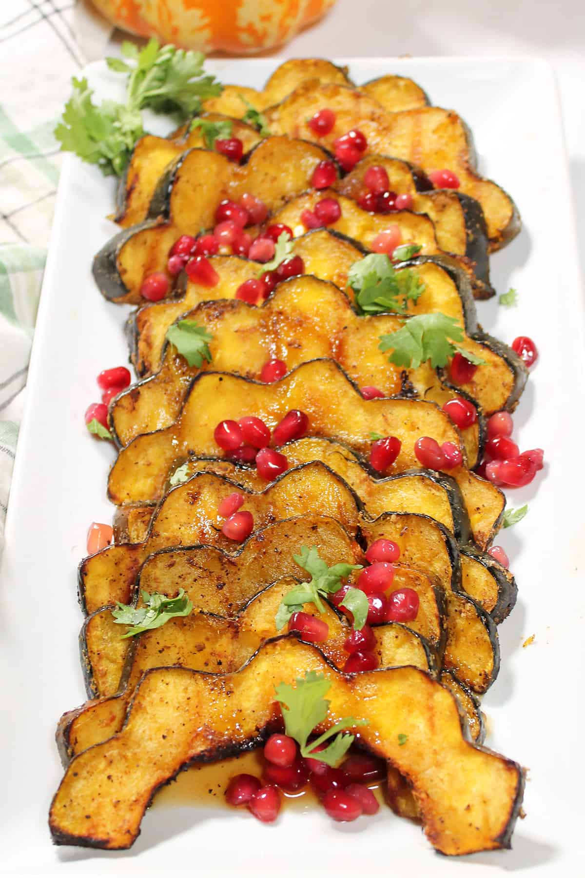 Closeup of grilled acorn squash with pomegranate arils garnish.