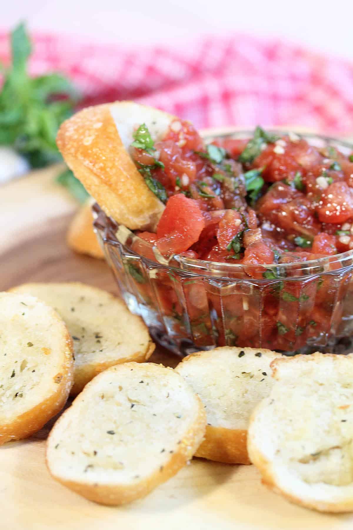 Dipping bread crisp into tomato basil bruschetta.