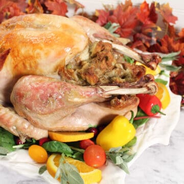 Roasted turkey with stuffing on dressed platter.