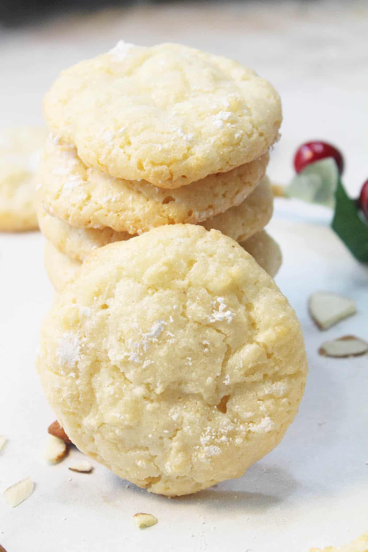 Stack of almond cloud cookies with one leaning in front.