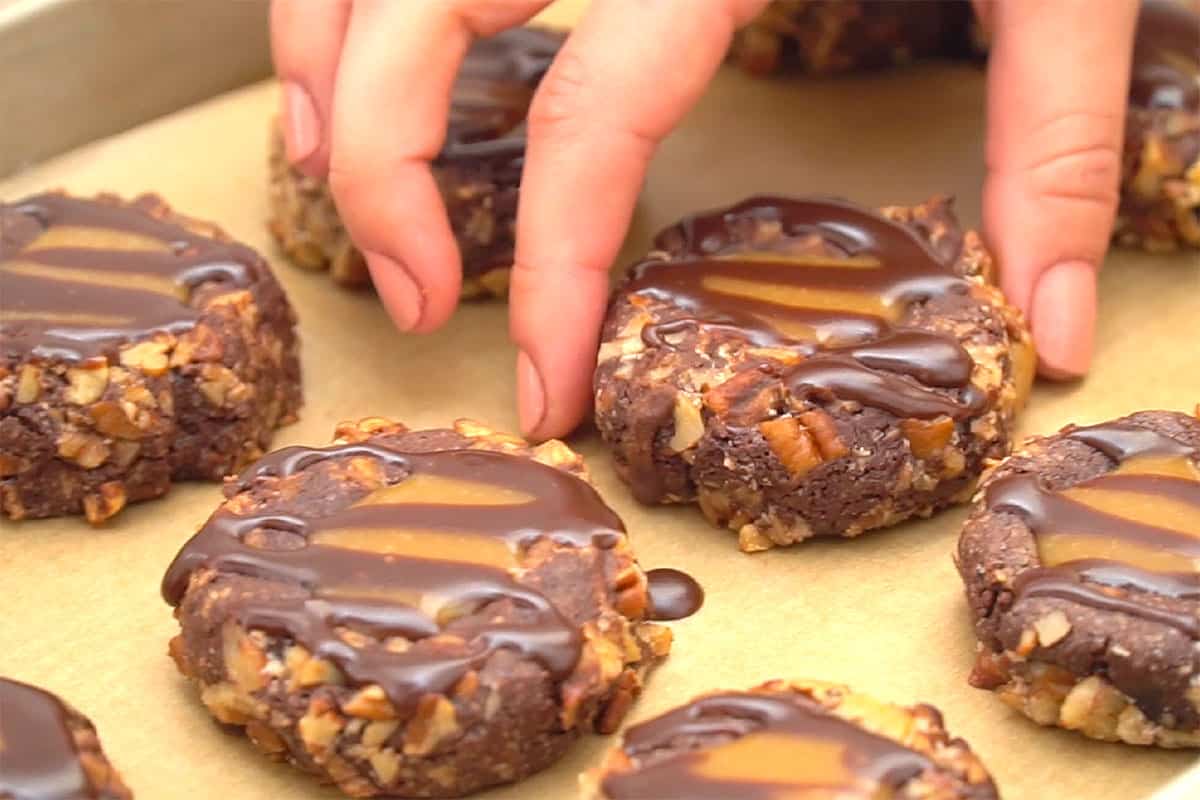 Reaching for cookie on cookie sheet.