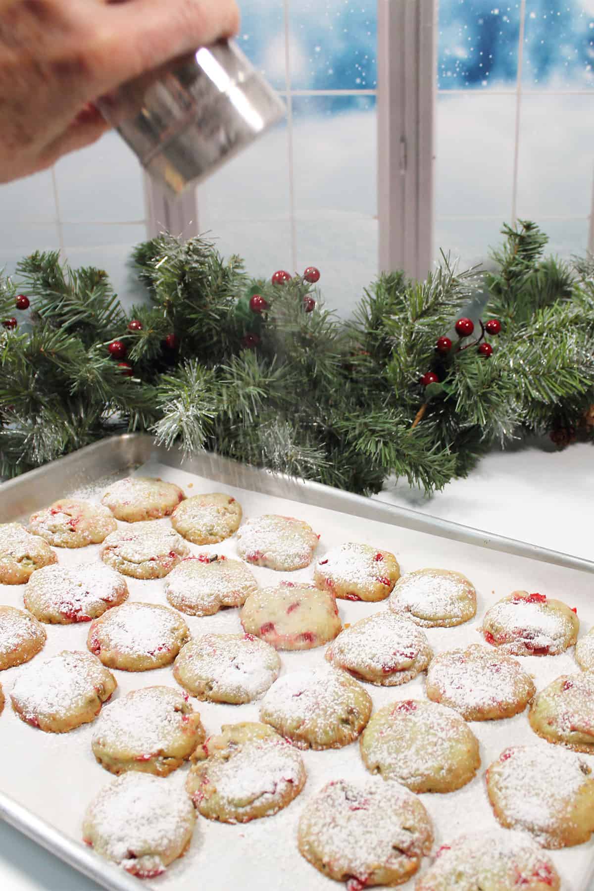 Sprinkling powdered sugar on cookies.