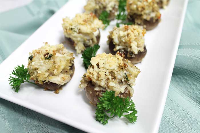 Closeup of Crab Stuffed Mushrooms on white platter.