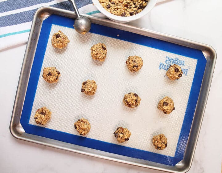 Scooped dough on lined cookie sheet.