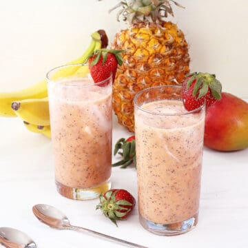 Two Topical Fruit Smoothies with chia seeds, garnished with strawberries.