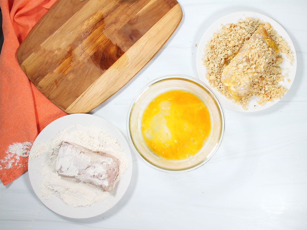 Assembly line to apply nut crust to fish.