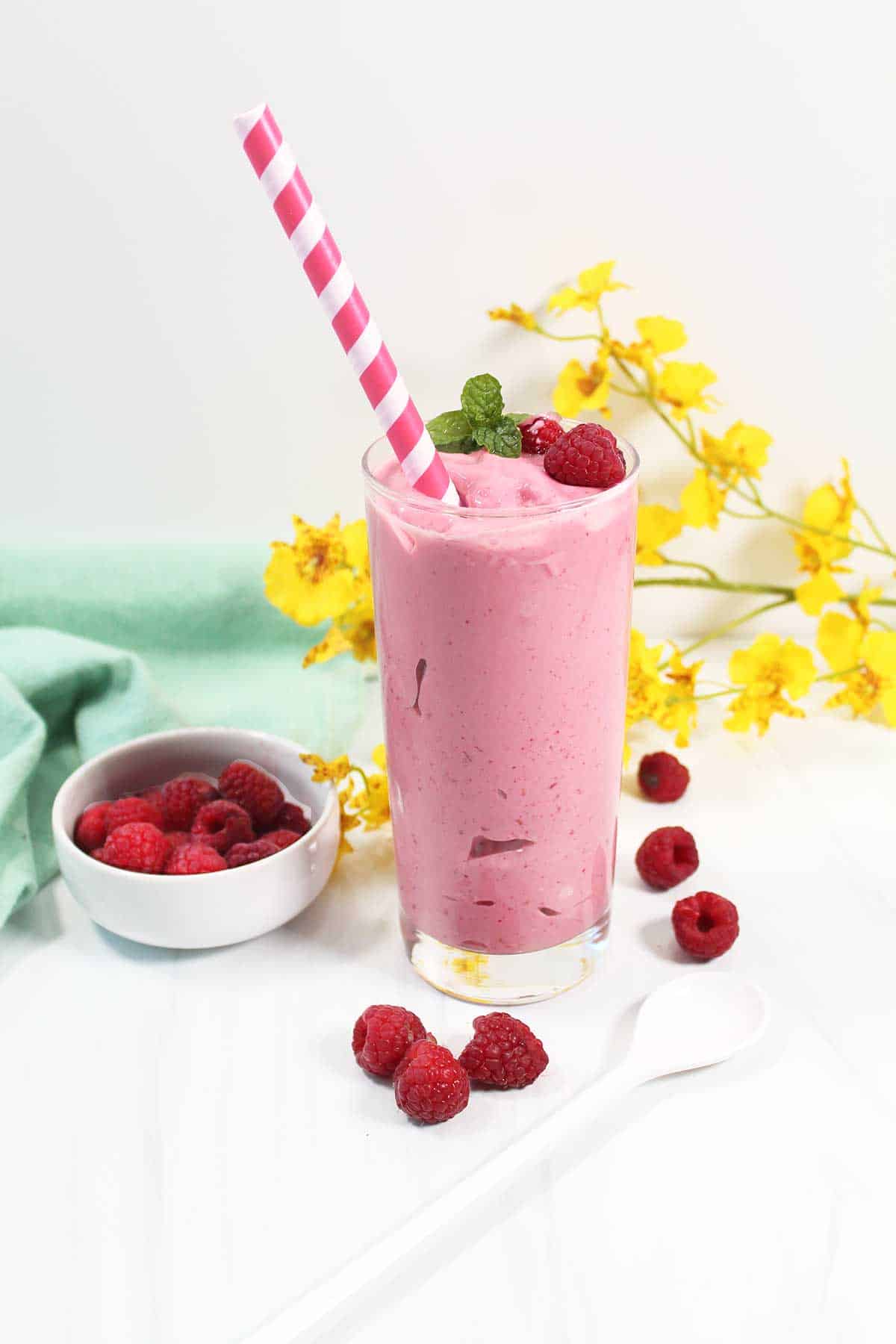 Smoothie in glass with pink striped straw.