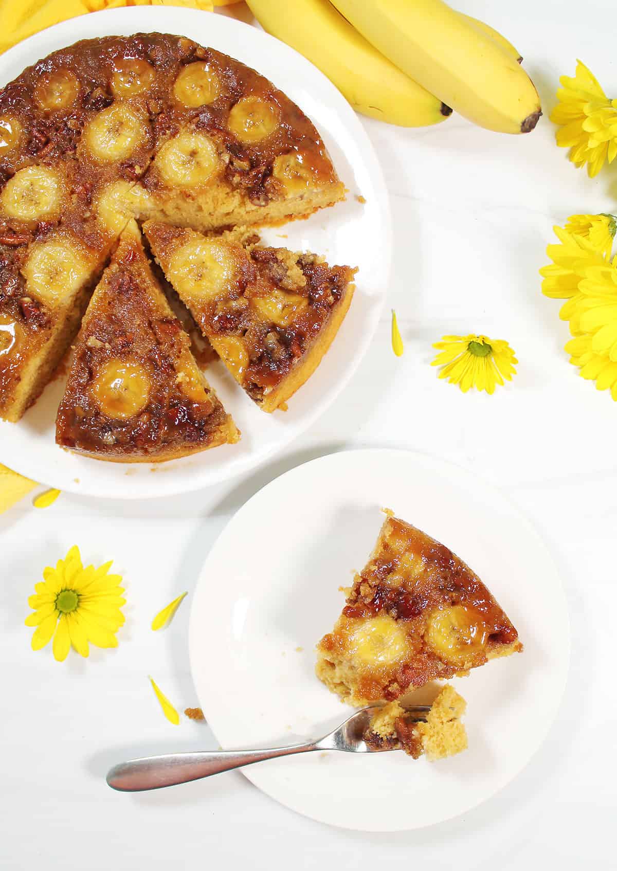 Banana Upside Down Cake sliced with slice on plate and fork with bite.
