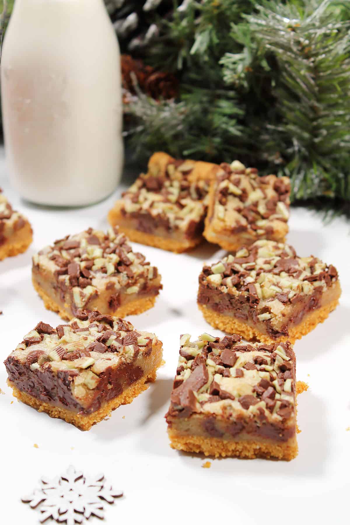 Mint chocolate chip cookie bars on table with milk bottle.
