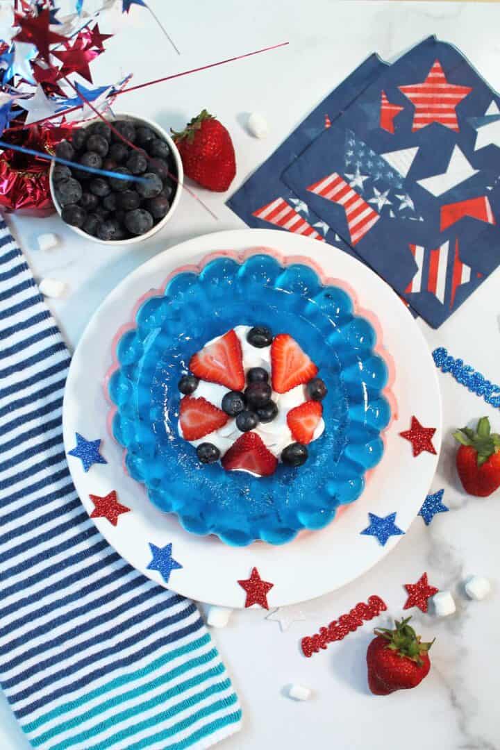 Overhead of July 4th jello recipe with patriotic napkins and blueberries.