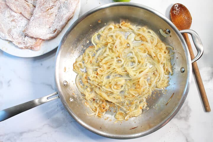 Beautiful sauteed onion next to floured chicken.