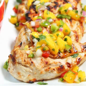 Platter of grilled lime chicken topped with salsa.