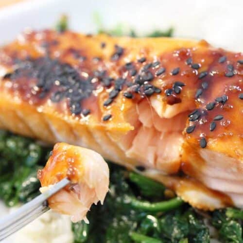 Closeup of baked salmon with bite on fork.