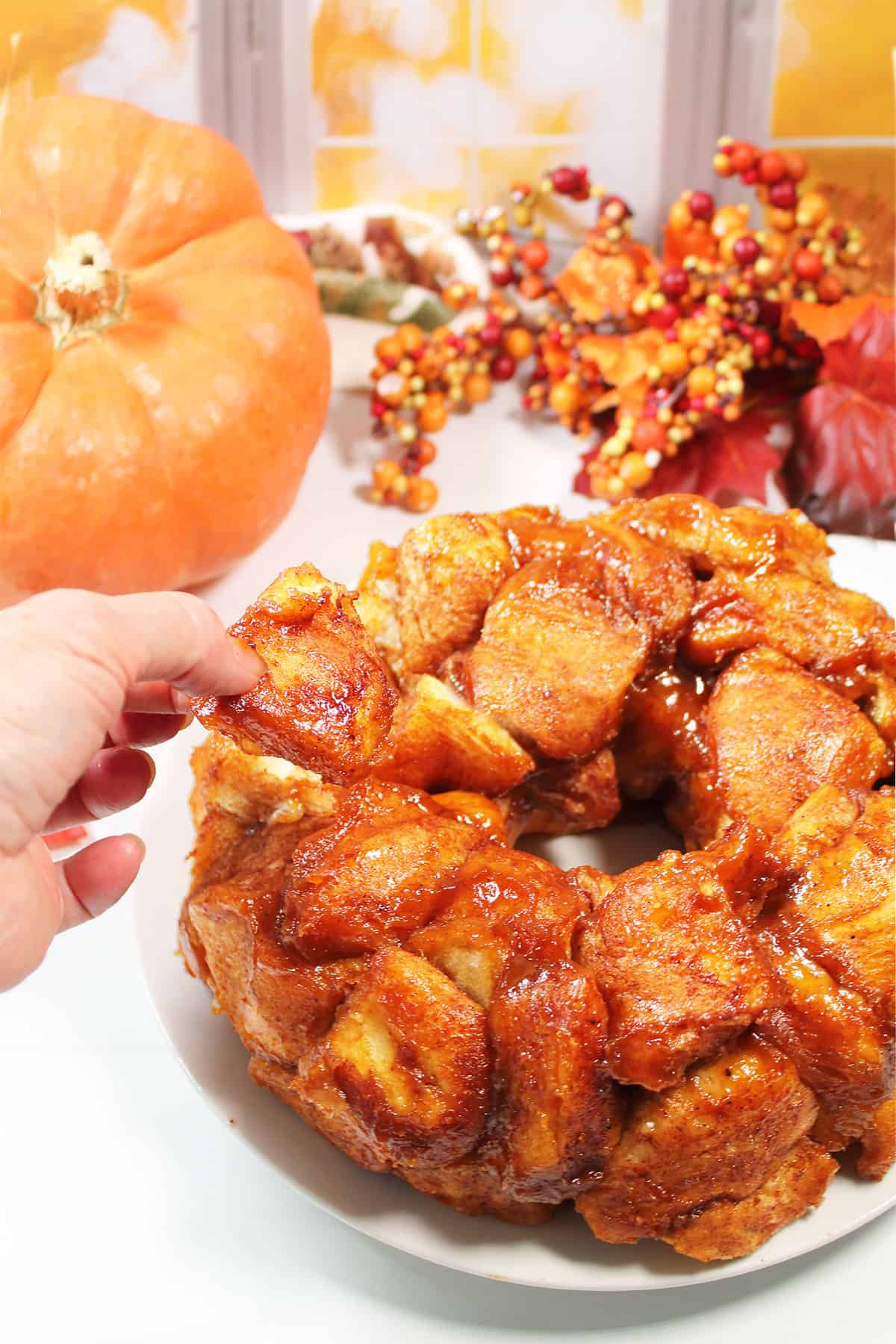 Pulling off piece of pumpkin monkey bread.
