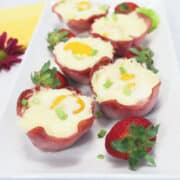 Platter of ham cheese and egg cups with strawberries.