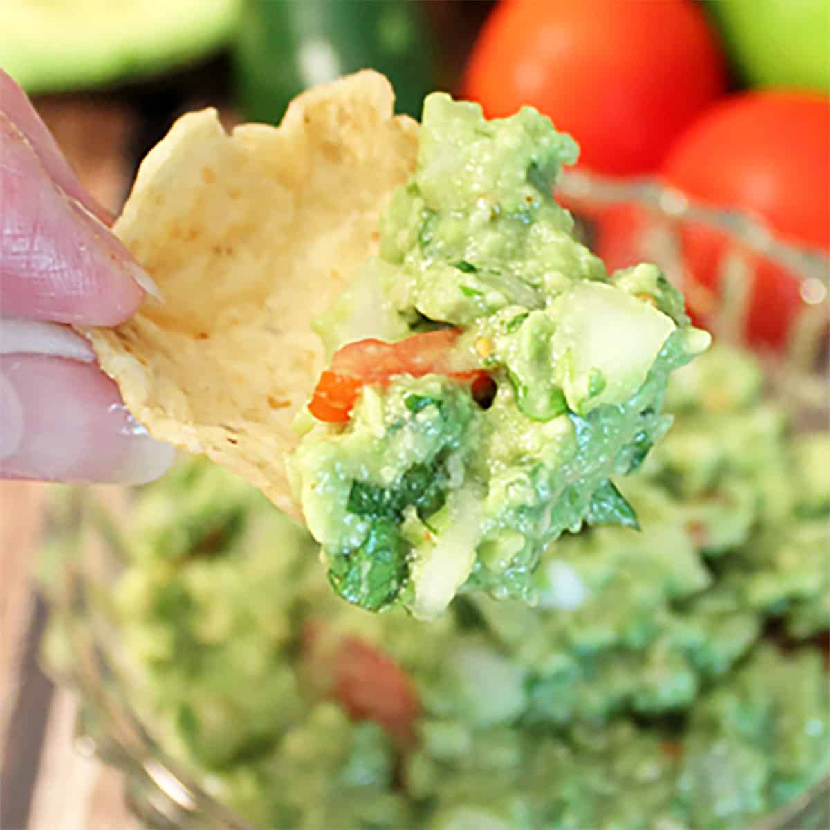 Classic guacamole scoop on tortilla chip is a must in guacamole recipes.