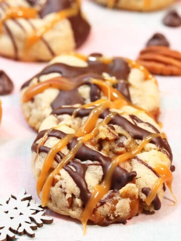 Turtle Cookies on parchment paper with caramels, chocolate chips and a snowflake.