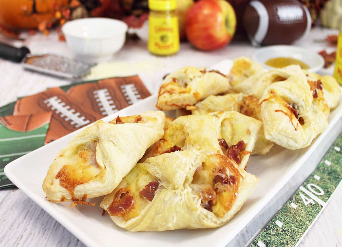 Cheesy Bacon Bundles plated on white plate with football and napkins around it.