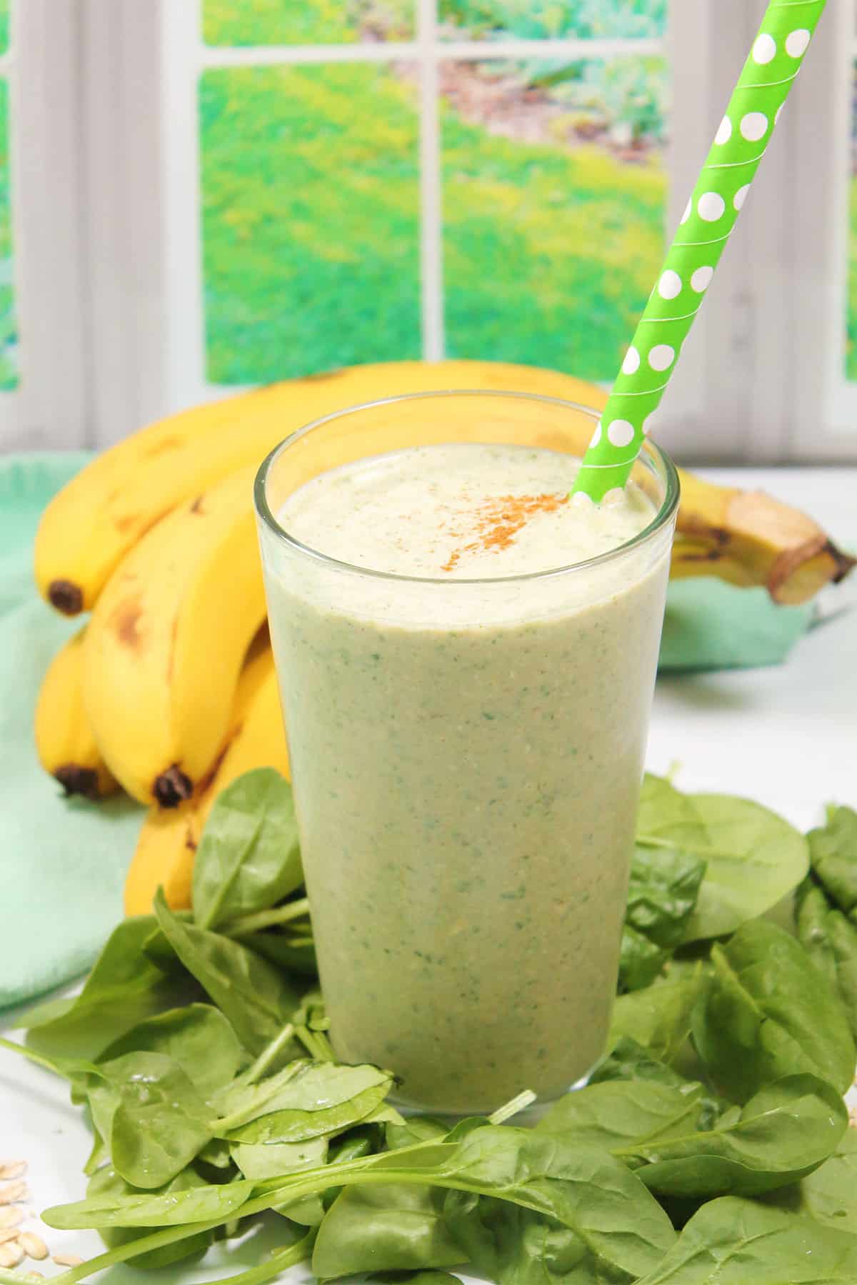 Spinach banana peanut butter smoothie in tall glass.