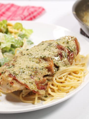 Closeup of chicken breast with basil cream sauce.
