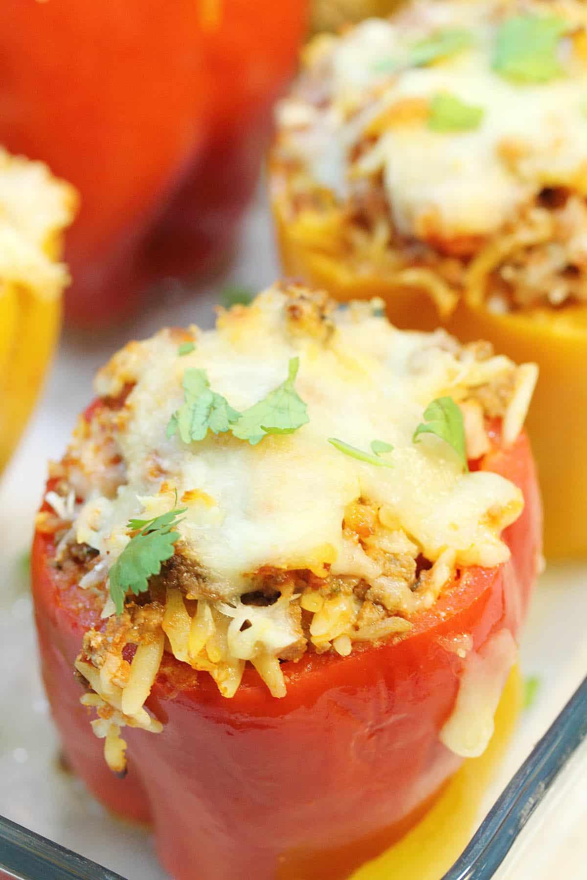 Looking down on stuffed red bell pepper in baking dish.