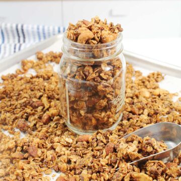 Honey Almond Butter Granola in jar among loose granola.