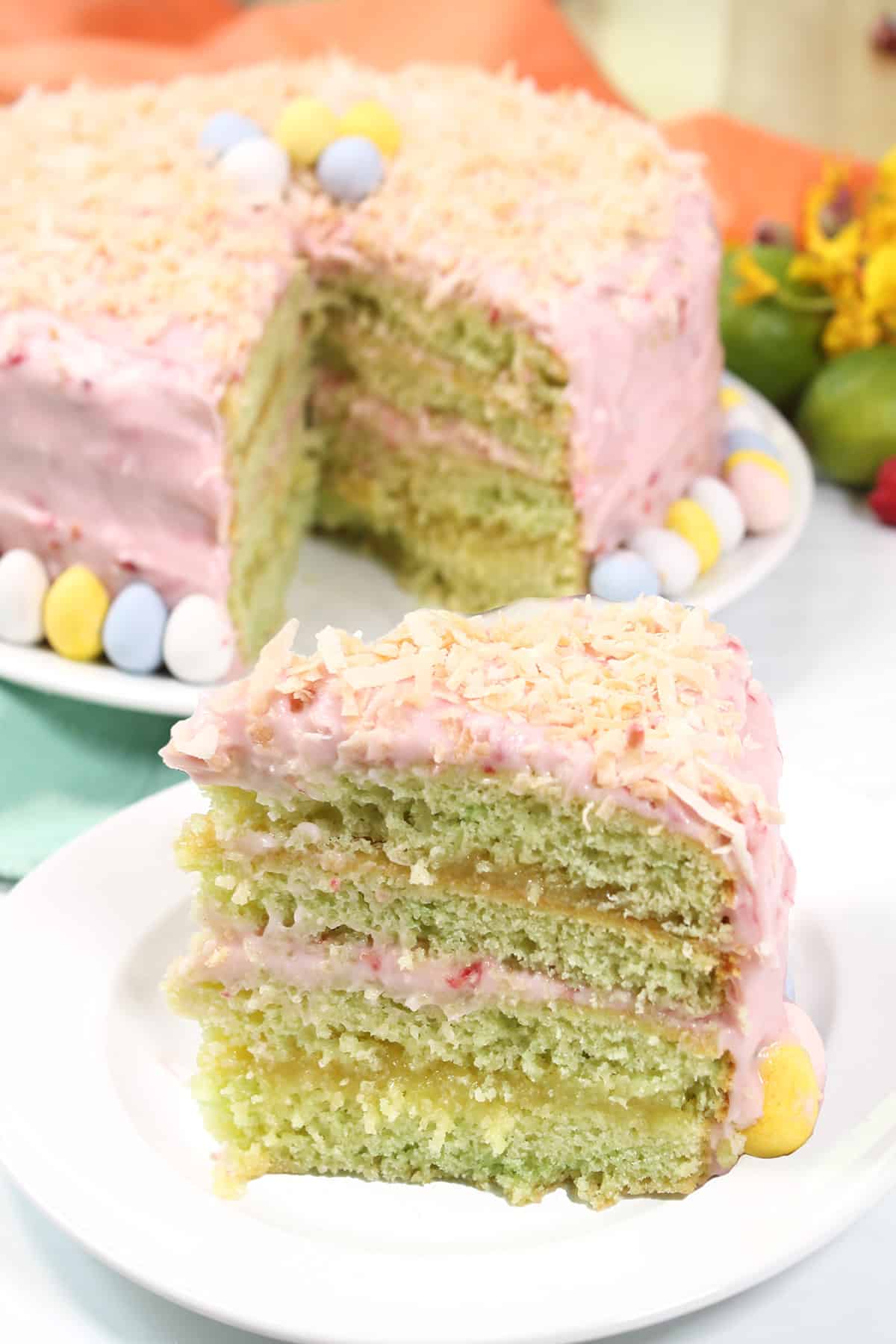 Slice of key lime layer cake in front of whole cake.