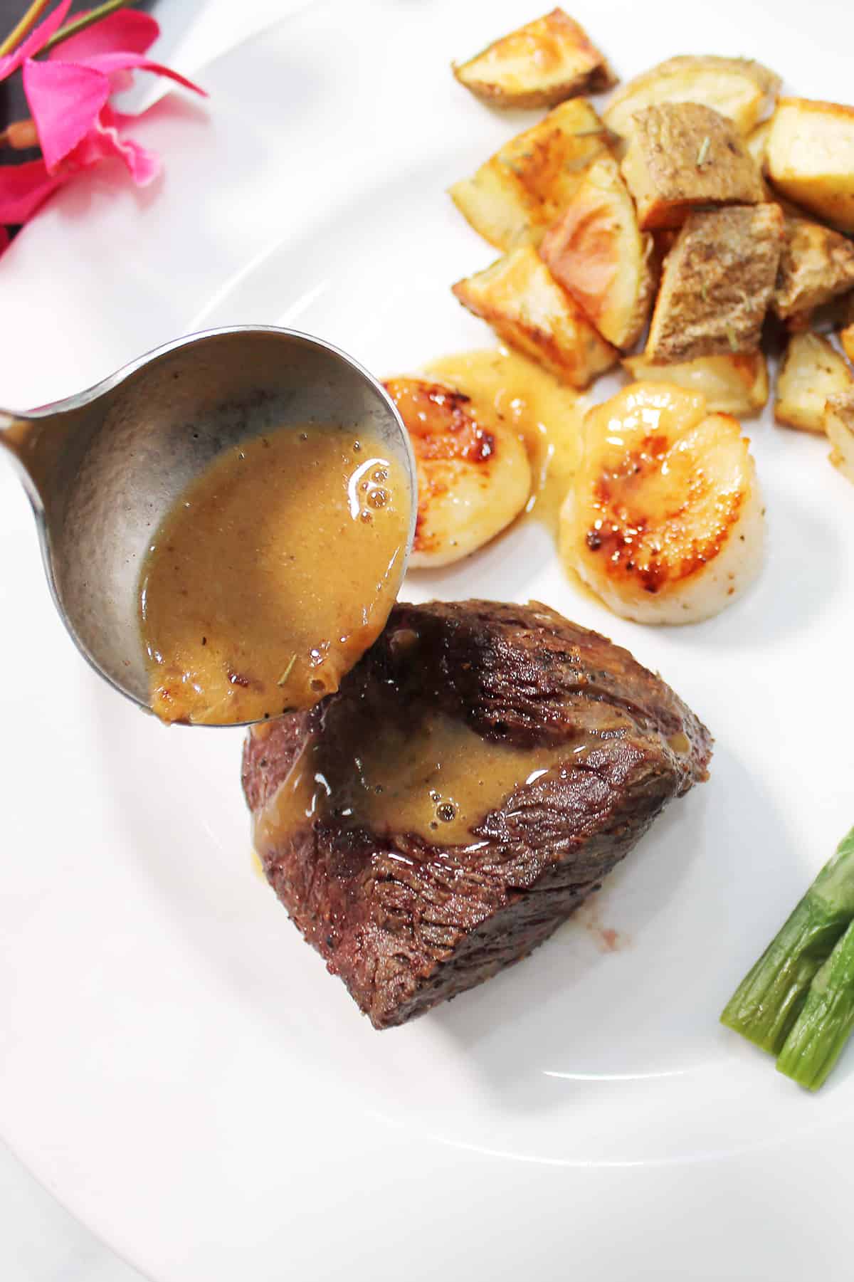 Drizzling butter sauce over steak.