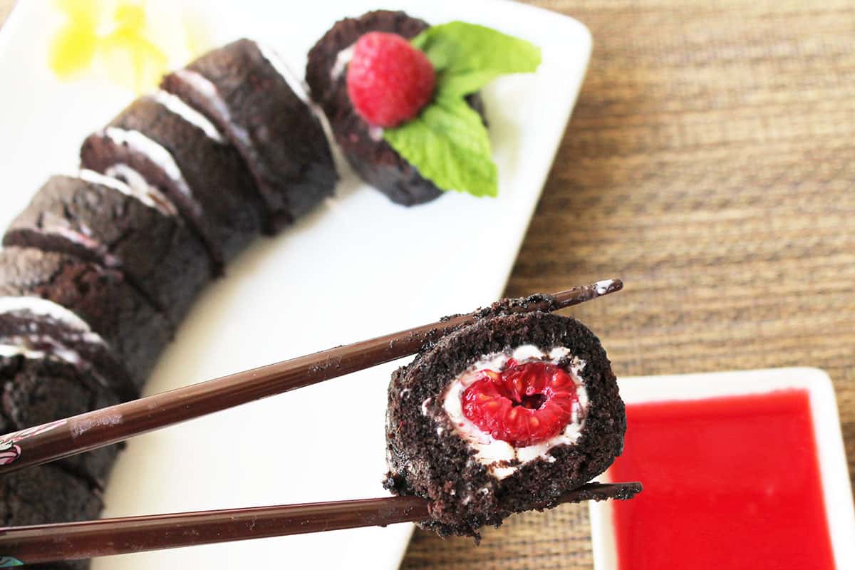 Holding slice of Chocolate Raspberry Dessert on chopsticks.