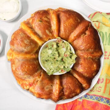 Overhead of taco monkey bread with guacamole in center.
