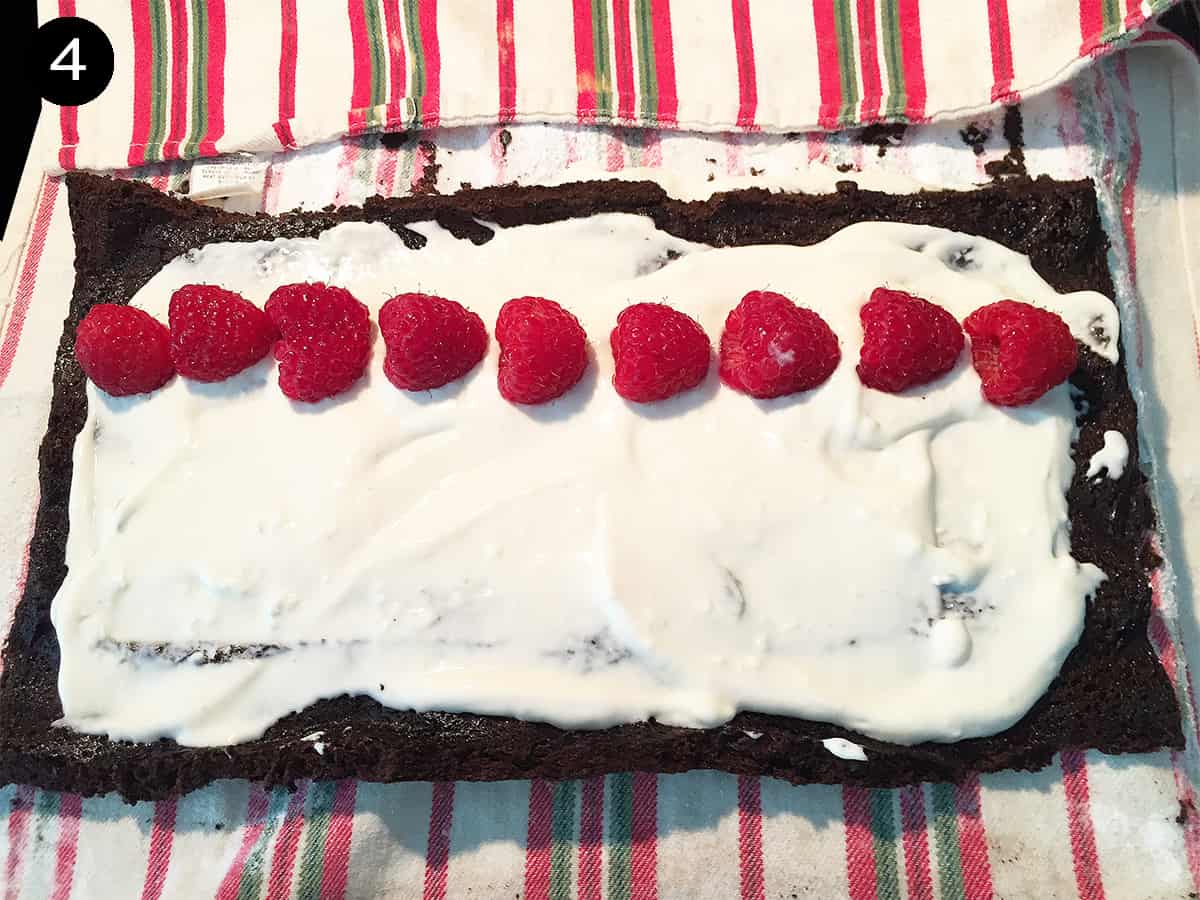 Spreading filling on cake and adding a row of raspberries step 4.