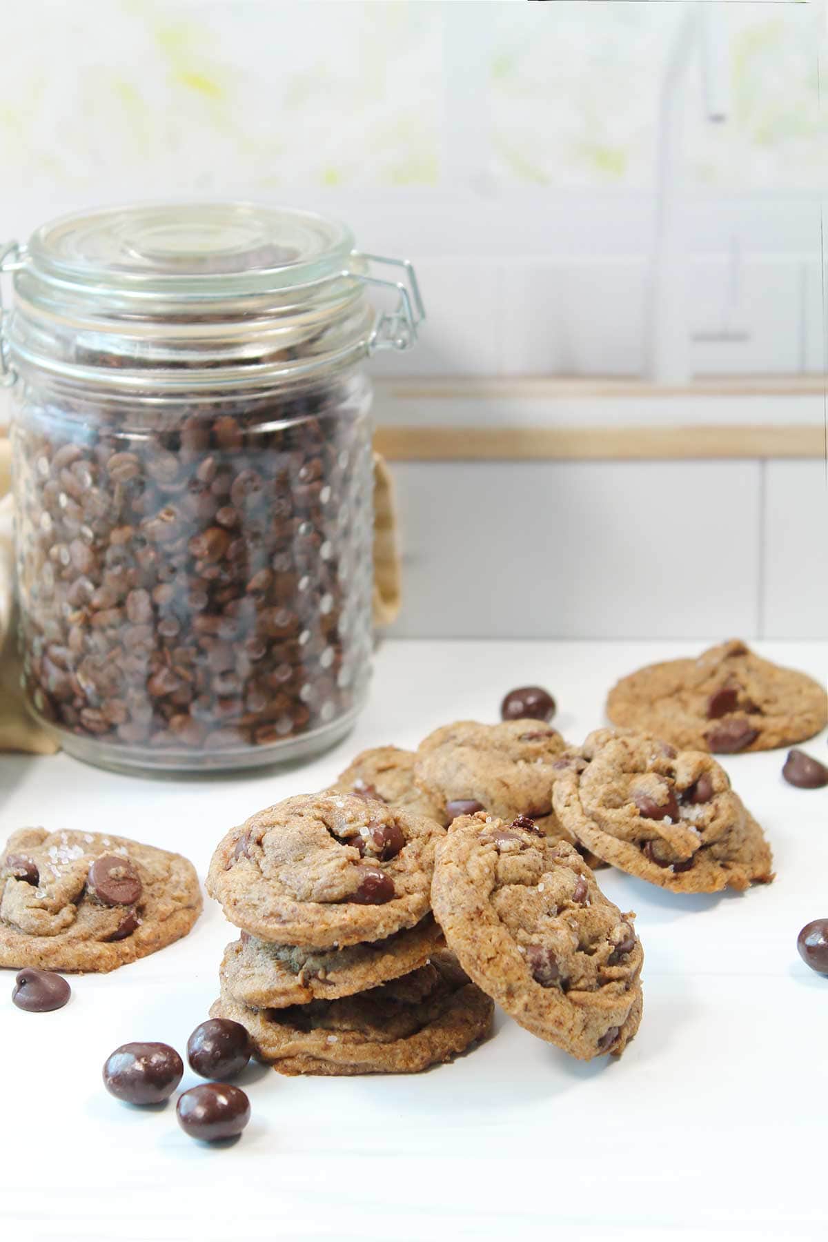Stack of espresso chocolate chip cookies by jar of coffee beans.