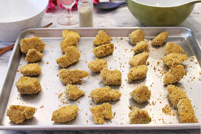Baked chicken pieces on cookie sheet