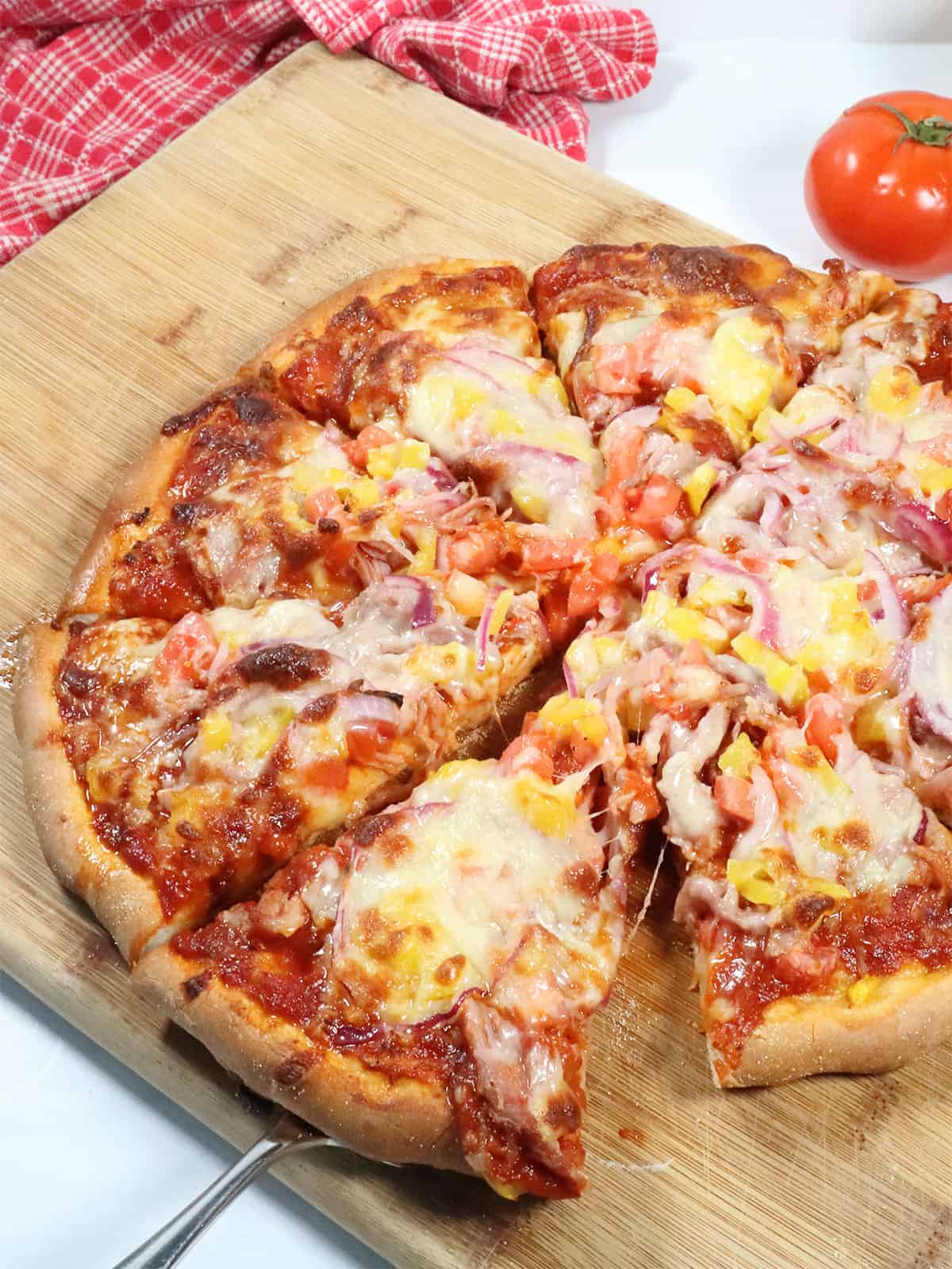 BBQ Pulled Pork Pizza with slice on server.