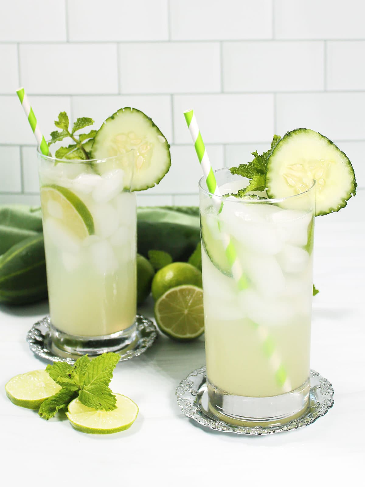 Two Cucumber Mojito cocktails with garnish and straws.