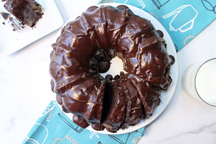 Overhead of glazed chocolate pound cake on white platter.